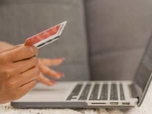 como vender pela internet: pessoa comprando online como cartão de crédito pelo laptop