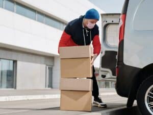 entregador colando mercadorias em uma van para realizar fulfillment