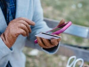 Imagem de uma pessoa segurando um celular e um cartão. Foto utilizada para ilustrar a nova funcionalidade do PagBank que transforma o celular em maquininha de cartão. Crédito: Pexels.