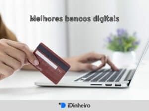 mãos usando um laptop e segurando um cartão de crédito, representando bancos digitais